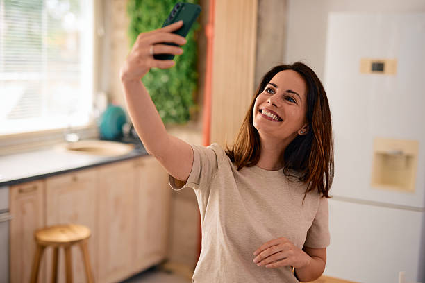 istock Happy woman taking a selfie in her modern kitchen 2217947438