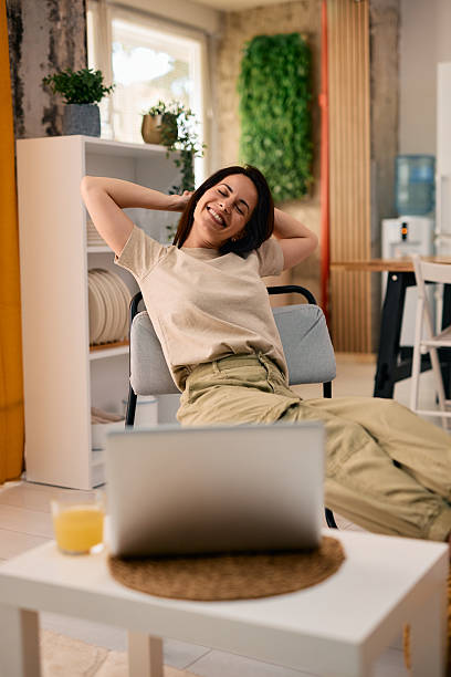 istock Young woman relaxing and stretching while working from home 2217947490