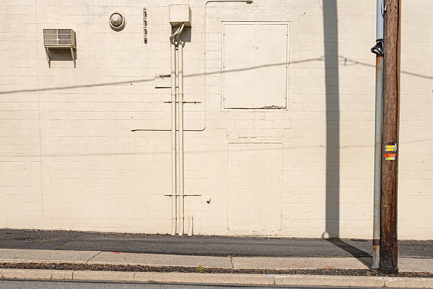 This is a background of a white industrial wall with a telephone pole and sidewalk in Ramsey, New Jersey, USA