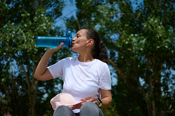 istock Woman Drinking Water Outdoors on a Sunny Day in Nature 2217950942