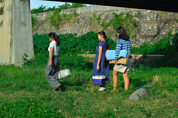 istock Girls walk beneath bridge surrounded by wild vegetation 2217951118