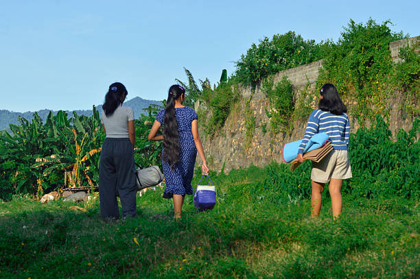 istock Girls walking side by side through grassy terrain 2217951247