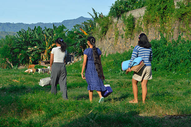 istock Girls pass by grazing goat among wild greenery 2217951272