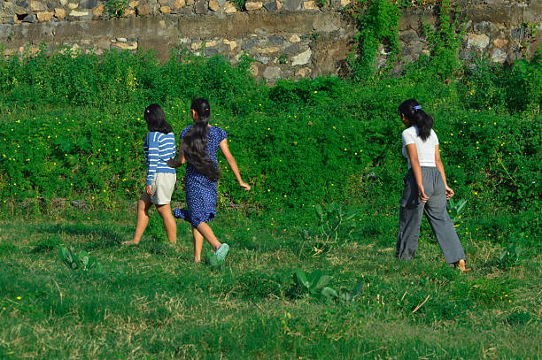 Elementary age playful children of Indian ethnicity standing/ Playing portrait together outdoor in nature during springtime.