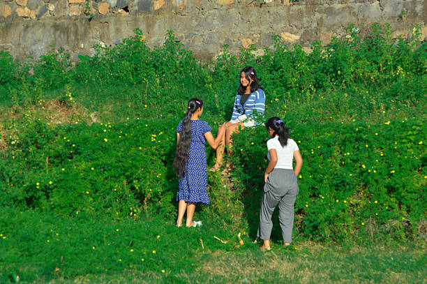istock One girl relaxes while others attempt to climb stone terrace 2217951576
