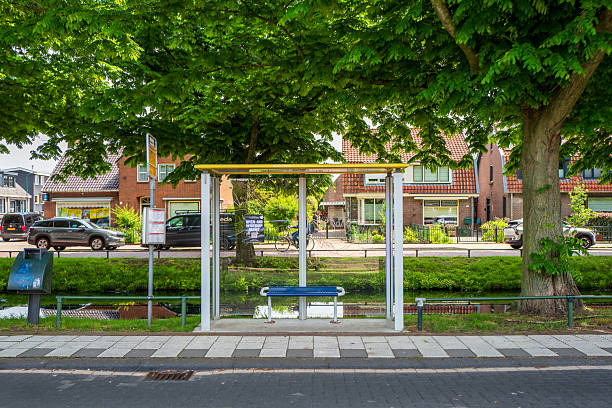 Bunschoten-Spakenburg, The Netherlands. May 31st, 2025: Modern bus stop with a transparent glass shelter in a typical Dutch urban setting. The scene shows clear infrastructure design focused on public transportation and accessibility, characteristic of city planning in the Netherlands.