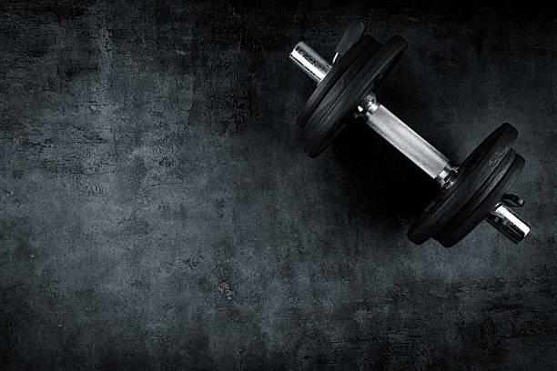istock Black metal dumbbells on black background 2217955589