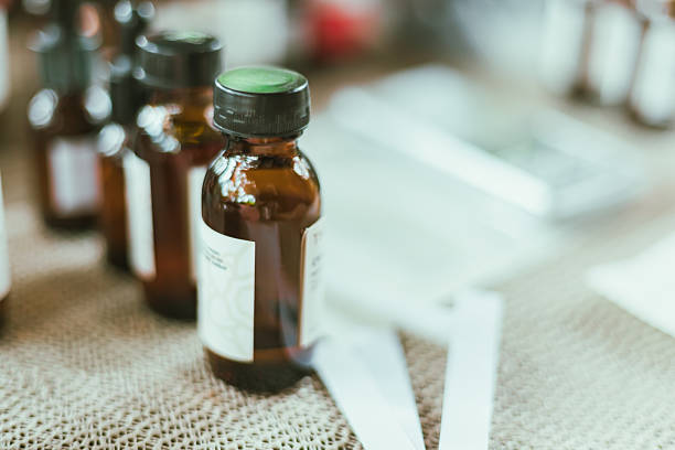 Shot of mature perfumer adding extra essential oil, perfume sample