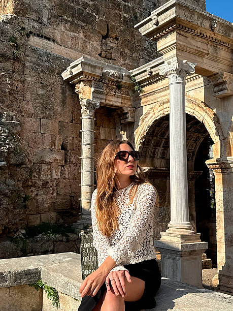 istock Woman in white lace top sits gracefully among ancient ruins in bright sunlight 2217955949