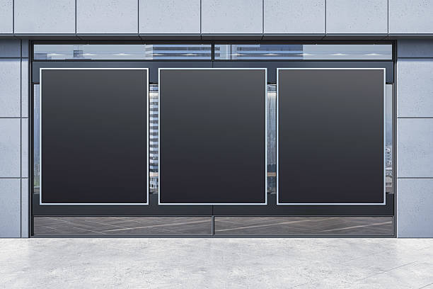 istock Three vertical black posters on modern retail store facade with blank mockup space for advertising or branding on urban street background. 3D Rendering 2217957772