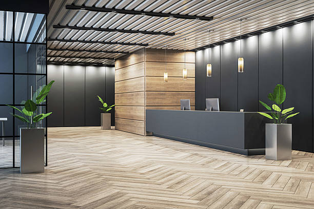 istock Modern empty office reception interior with wooden floor, dark counter, and plants in corridor under ceiling lights, stylish business hall design. 3D Rendering 2217957789