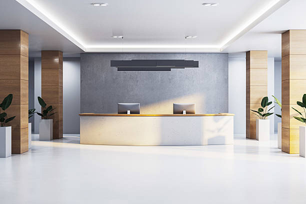 istock Modern corporate office reception with minimalist desk, wooden columns, concrete wall, and plants in a bright, empty interior space. 3D Rendering 2217957797