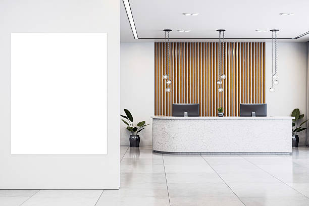 istock Vertical blank canvas on wall inside modern corporate office reception with clean white interior, wood panel accents and marble desk counter. 3D Rendering 2217957807