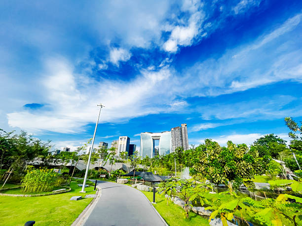 Panoramic view of Queen Sirikit Park in Bangkok Chatuchak. In foreground is footpath and in background is modern skyline at Phahonyothin Road. Park is located at  Kamphaeng Phet 2 Rd in Bangkok Chatuchak. In center background is new headquarters of BTS Group