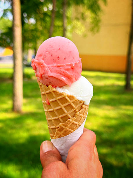 istock Strawberry and Vanilla ice cream in a waffle cone on a hot summers day 2217963659