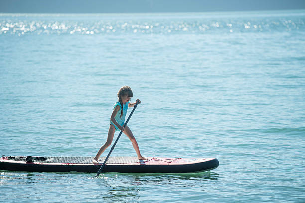 istock Young girl paddles SUP board on lake 2217971735