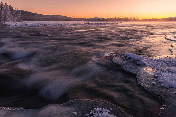 istock River ice forms along shoreline during a winter sunset in Norway, showcasing nature's tranquil beauty and cold temperatures 2217972240