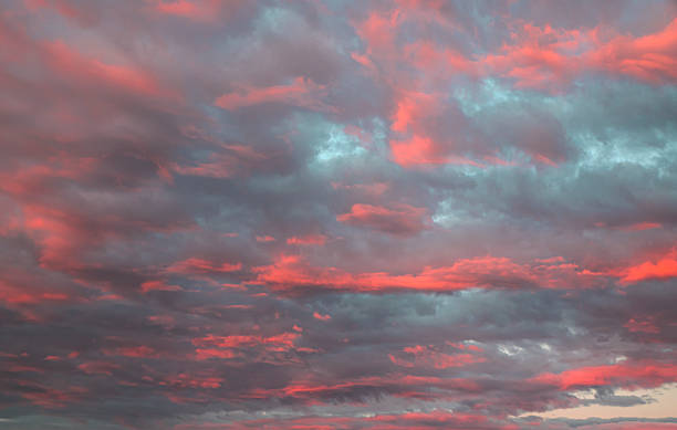 istock Clusters of pink-tinted clouds forming in the sky during sunset. 2217977595