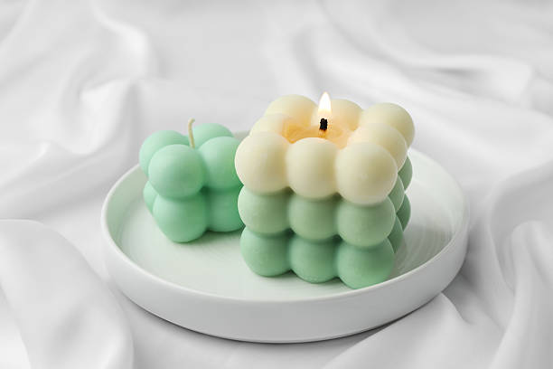 istock Stylish bubble candles on white cloth, closeup 2217980986