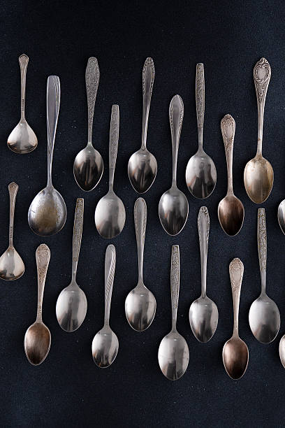 istock Set of different spoons. Silver cutlery on a black background. Spoon on the table 2217981213