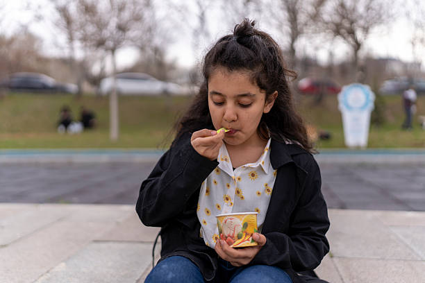 istock Girl eating ice-cream outside (in the park). 2217981600