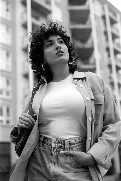 Young stylish woman posing in urban setting, looking up