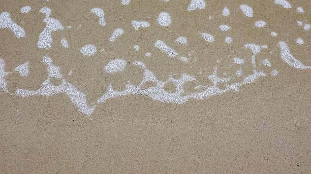 istock Foam from the waves on the beach 2217982895