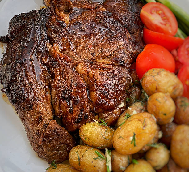 istock Beef steak with new potatoes, herbs and tomatoes 2217984119