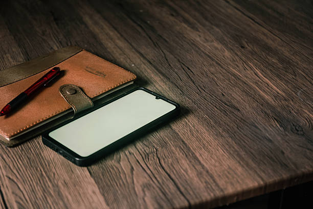 A book and a smartphone with a white screen are on the table.