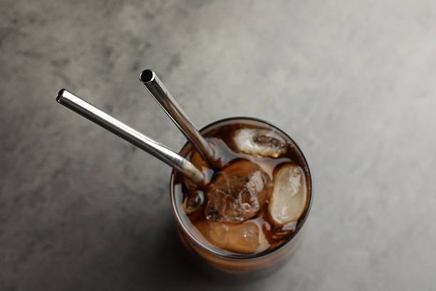 istock Tasty refreshing drink with straws in glass on grey table, top view 2217988536