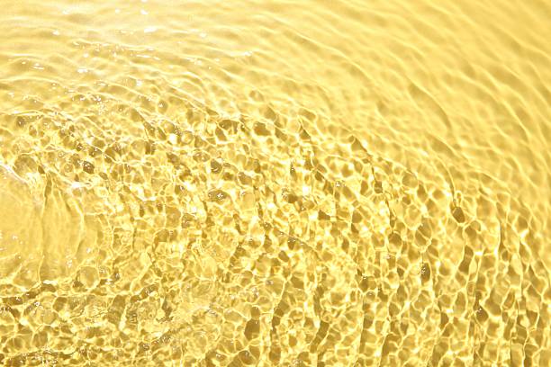 istock Rippled surface of clear water on yellow background, closeup 2217988606