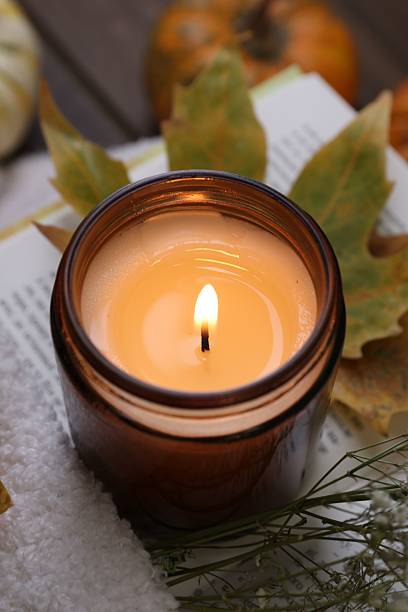 istock Burning candle, open book, sweater and autumn decor on table, closeup 2217989949