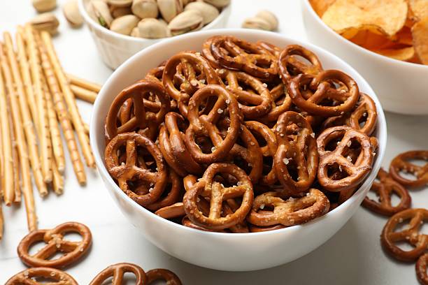 istock Delicious pretzel crackers and other snacks on white table, closeup 2217989959