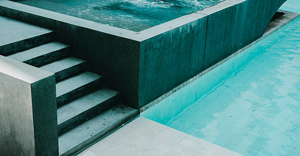 istock Nice Swimming Pool. Modern minimalist pool design with clear blue water and stylish stone steps in an outdoor setting 2217991168
