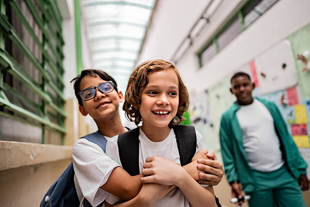 istock Schoolboys embracing and having fun in the school hallways 2217995130