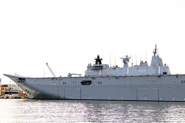 istock Closeup Navy ship at the dock, white background with copy space 2217995134