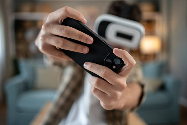 istock Teenager playing augmented reality game using smartphone and vr headset 2217995235