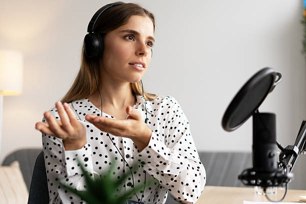 istock Podcaster creating online audio content wearing headphones and speaking into microphone 2217995907