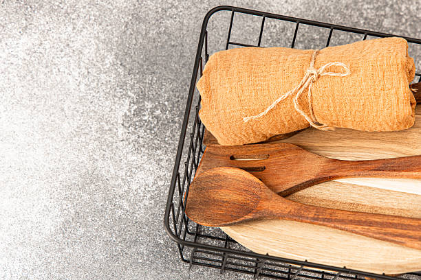 istock Kitchen utensils and textiles arranged in a basket on a textured gray surface 2217998446