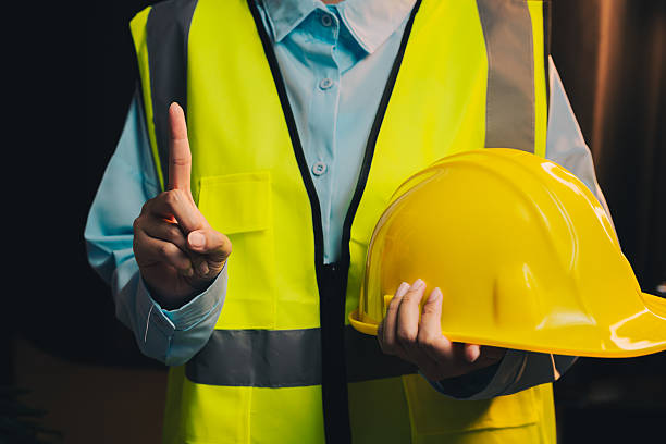 istock Engineer concept. Construction Worker in Safety Vest Holding Hard Hat with One Finger Raised Indicating Caution or Warning Sign 2217999505
