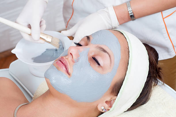 istock Young woman getting facial mask 2218000302