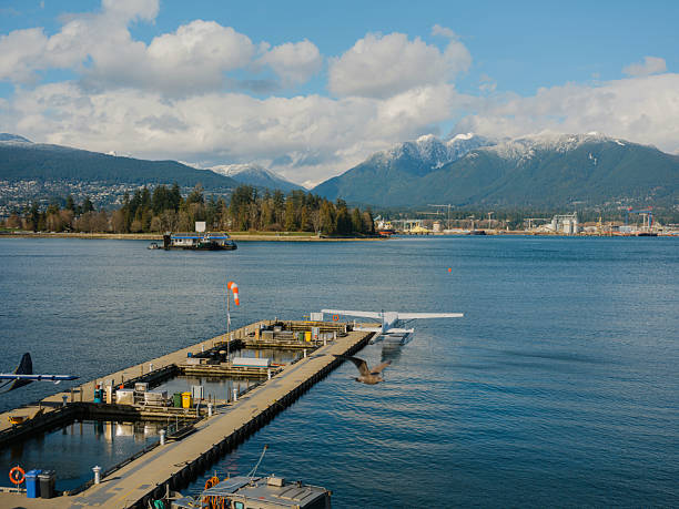 Seaplane and ferry in Vancouver harbor, Canada, highlighting alternative transportation methods with urban skyline and coastal mountains in the background.