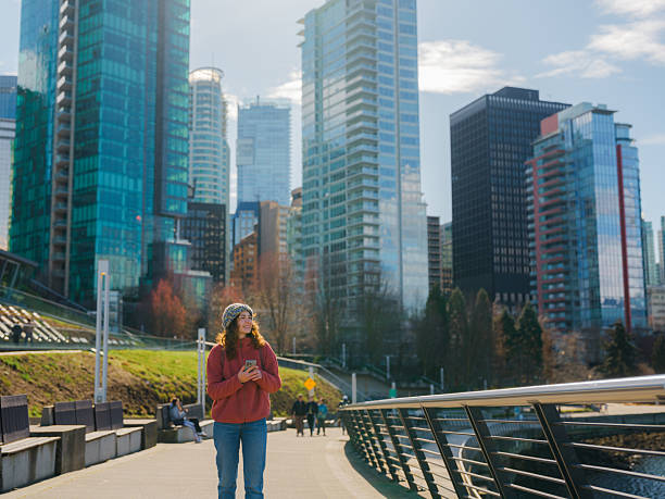 istock Woman using smartphone walking in Vancouver city, Canada 2218001769