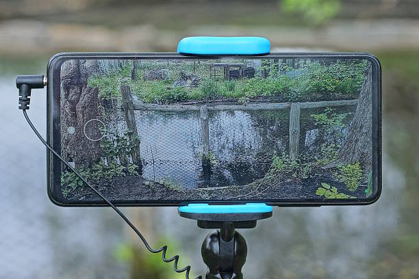 one smartphone on a long selfie stick on a summer street