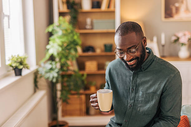 istock Smiling man drinking coffee in cozy living room 2218002708