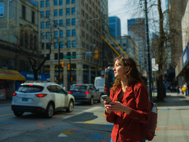 Woman using smartphone walking in Vancouver downtown