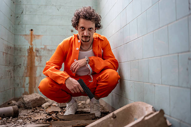 istock Man in Orange Jumpsuit in a Run-Down Urban Environment 2218009783
