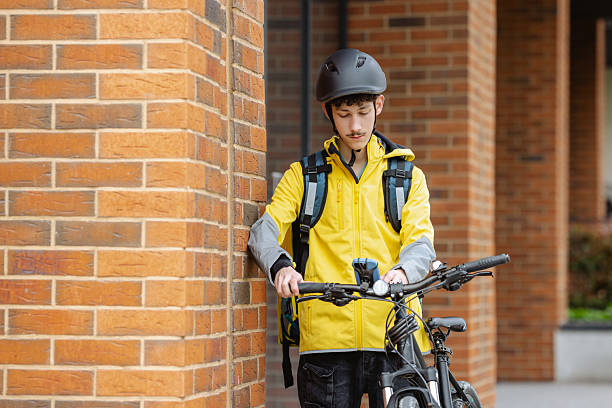istock Delivery courier with a bicycle taking a break on city streets 2218011442