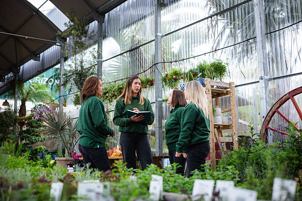 Garden center employees discussing work in greenhouse