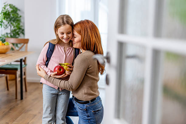istock Mother Hugging Daughter With Fruits in Kitchen Before School 2218017431